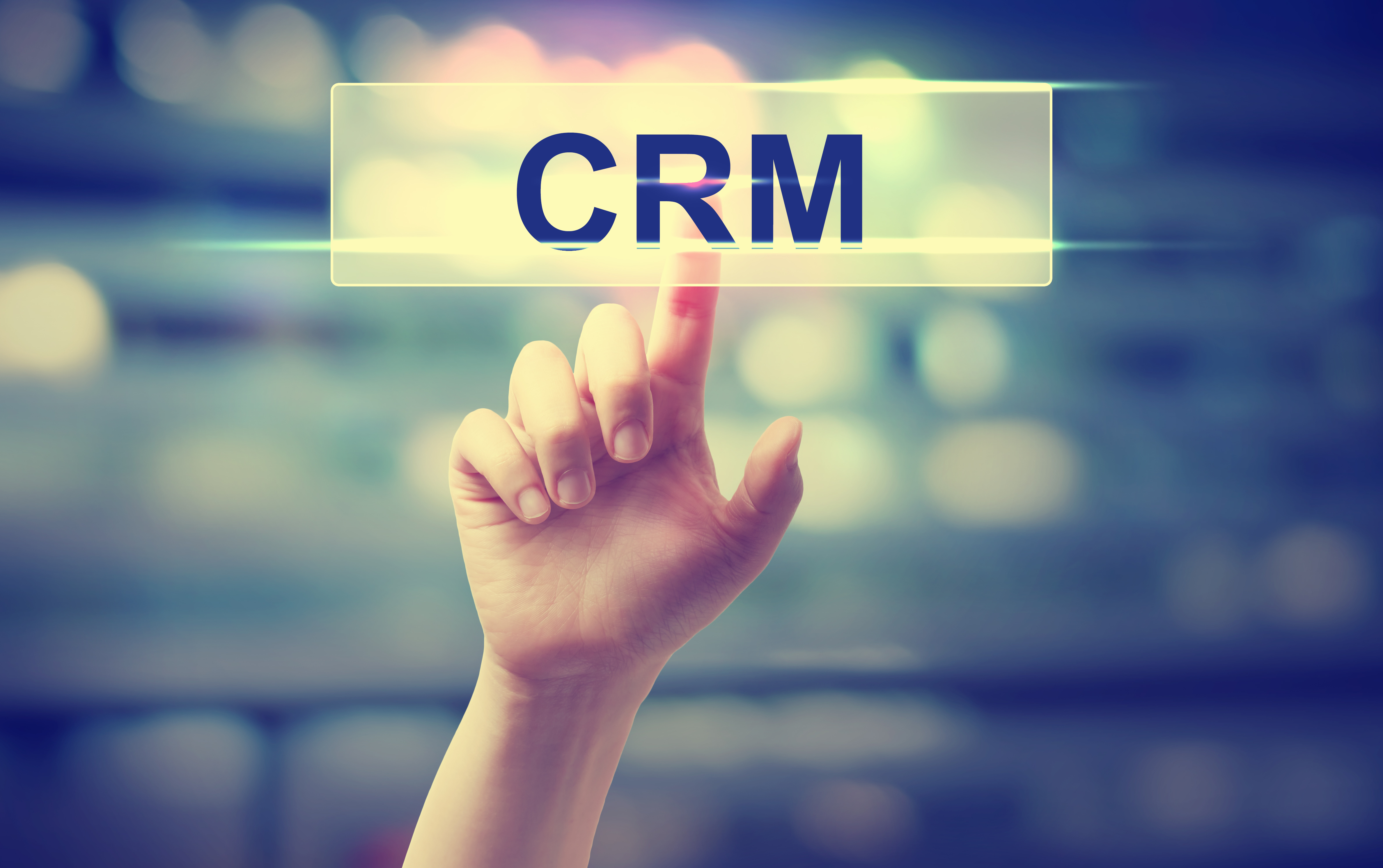 CRM - Customer Relationship Management concept with hand pressing a button on blurred abstract background